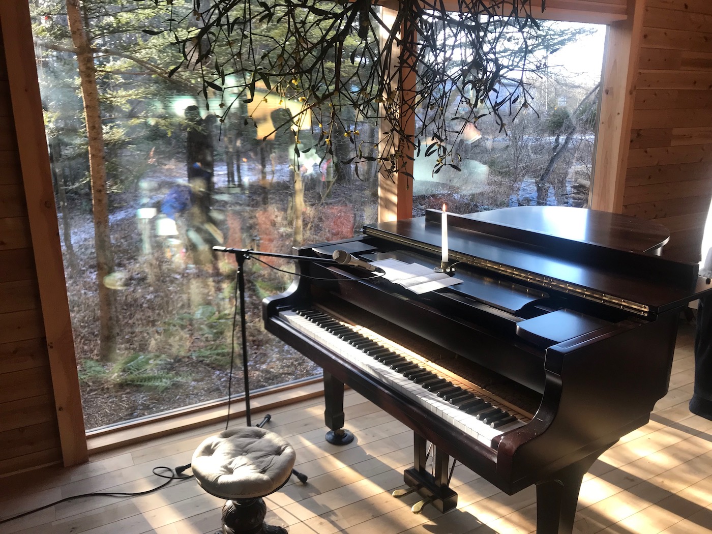 冬はピアノの向こう、大きな窓から見える森に夕日が沈みます