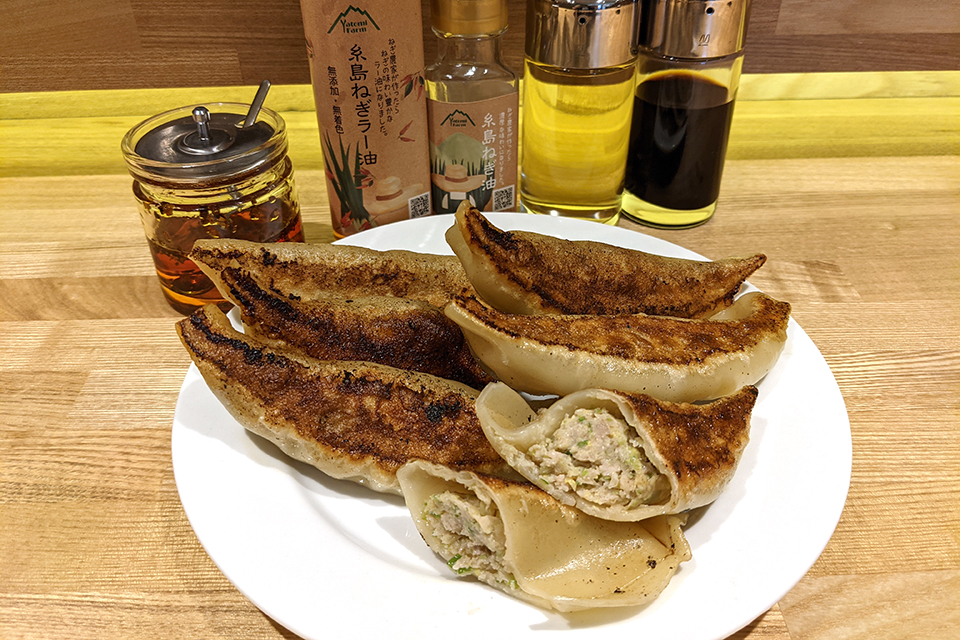 餃子は6個で720円、3個で400円。後ろにうつっている「糸島ねぎ油」「糸島ねぎラー油」は奥様の出身地・福岡県糸島市から取り寄せたもの。