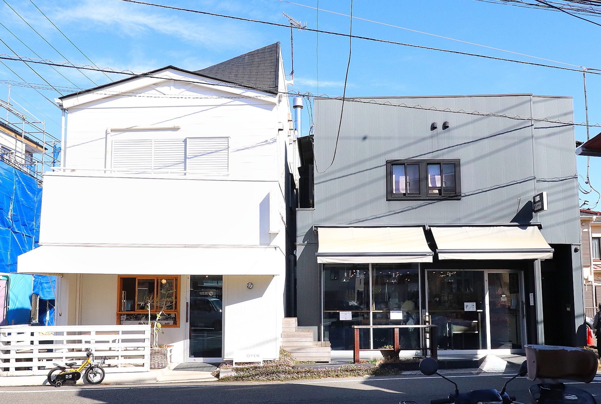 左の白い建物が『CORNER27 coffee works』（焙煎所とカフェ）／ 右の黒い建物が『27 COFFEE ROASTERS』