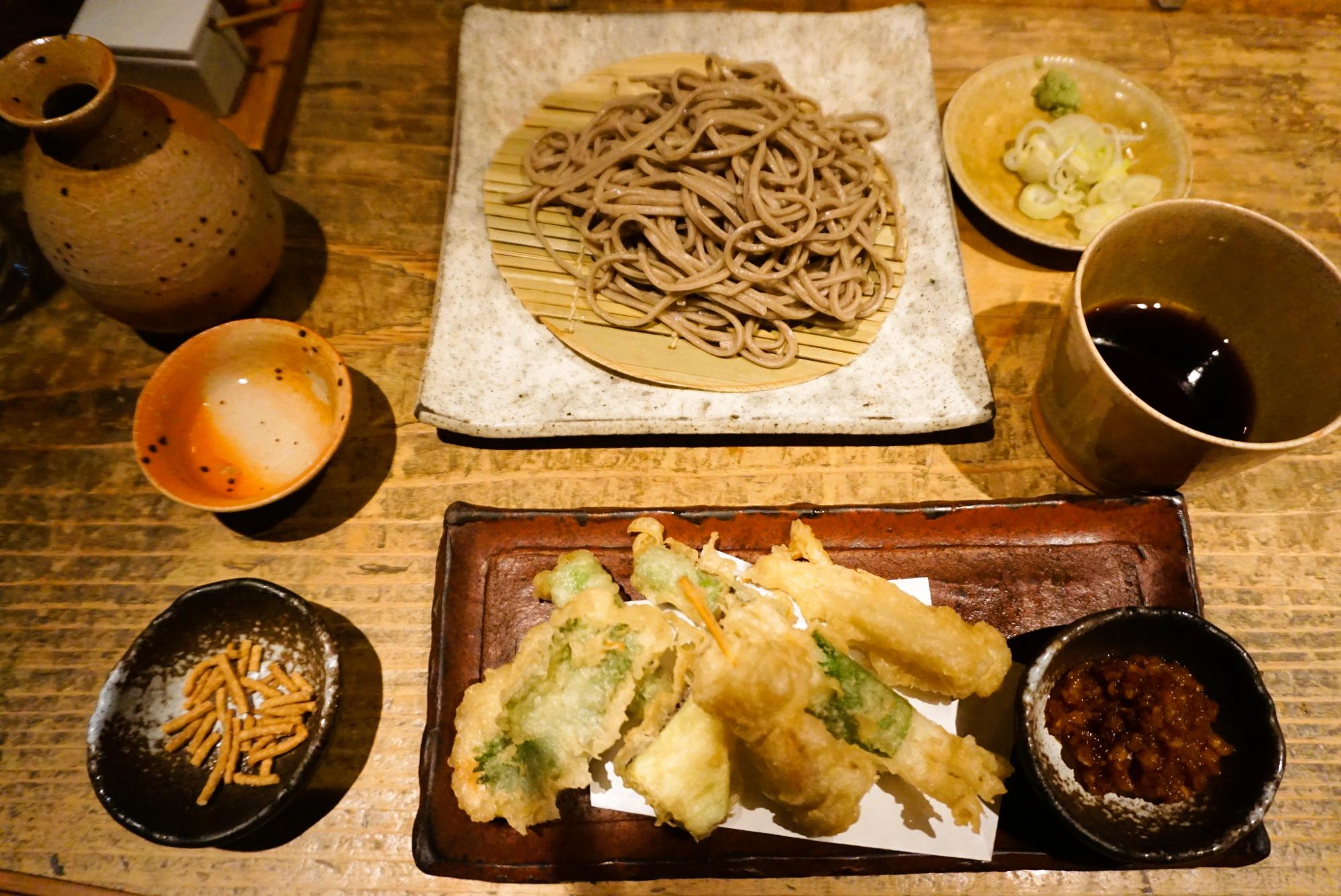 切り蕎麦は細切りか太麺を選べるので細切りにしました。天ぷらもたっぷり。手前左にあるのは、蕎麦のフライのお通し